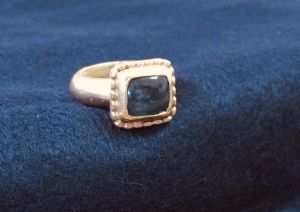 Gegoten gouden ring met labradoriet in gouden kast, met gouden balletjes