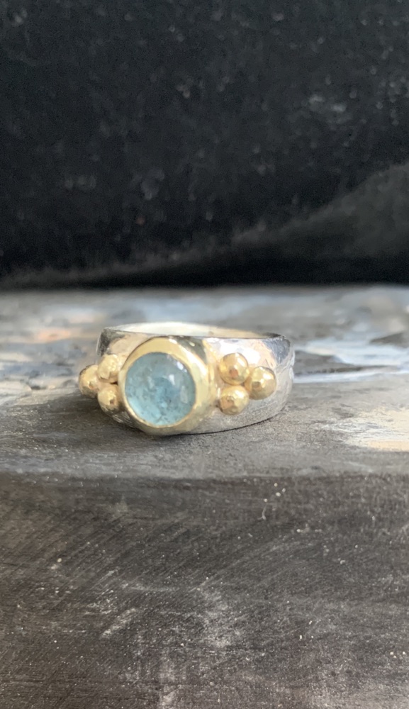 Zilveren ring met aquamarijn in gouden kast en gouden bolletjes