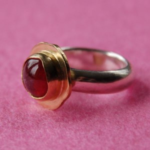 Zilveren ring met roze tourmalijn in gouden kast