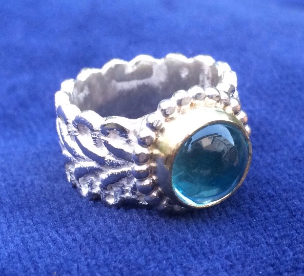 Zilveren ring met topaas in gouden kast