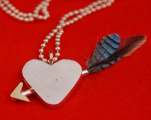 Zilveren snoepjeshart met pijl (gouden detail) en veertjes Vlaamse Gaai